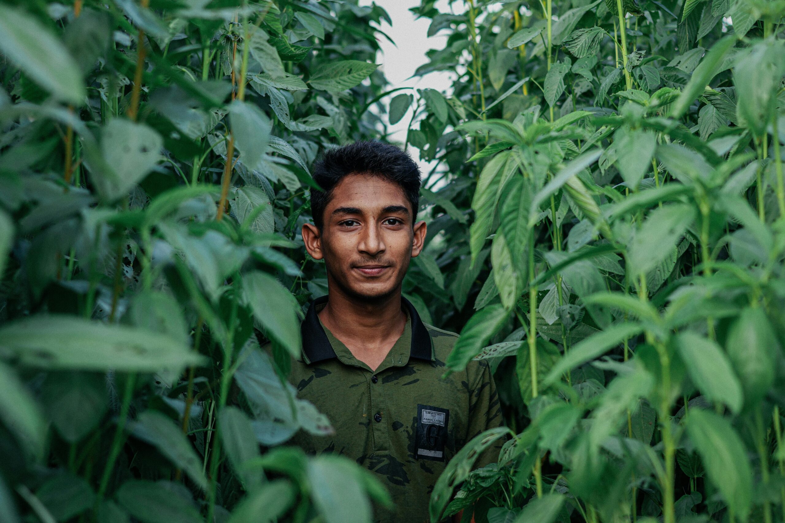 Smiling farmers standing beside their lush vegetable fields