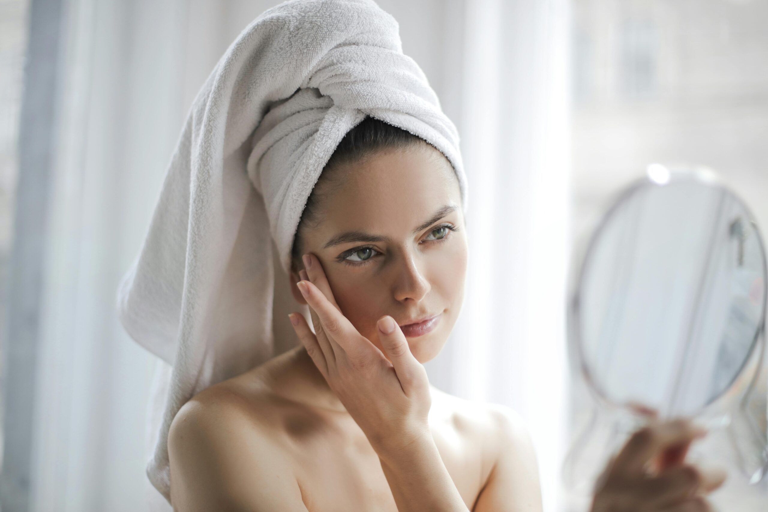 Woman examining her clear complexion in sunlight