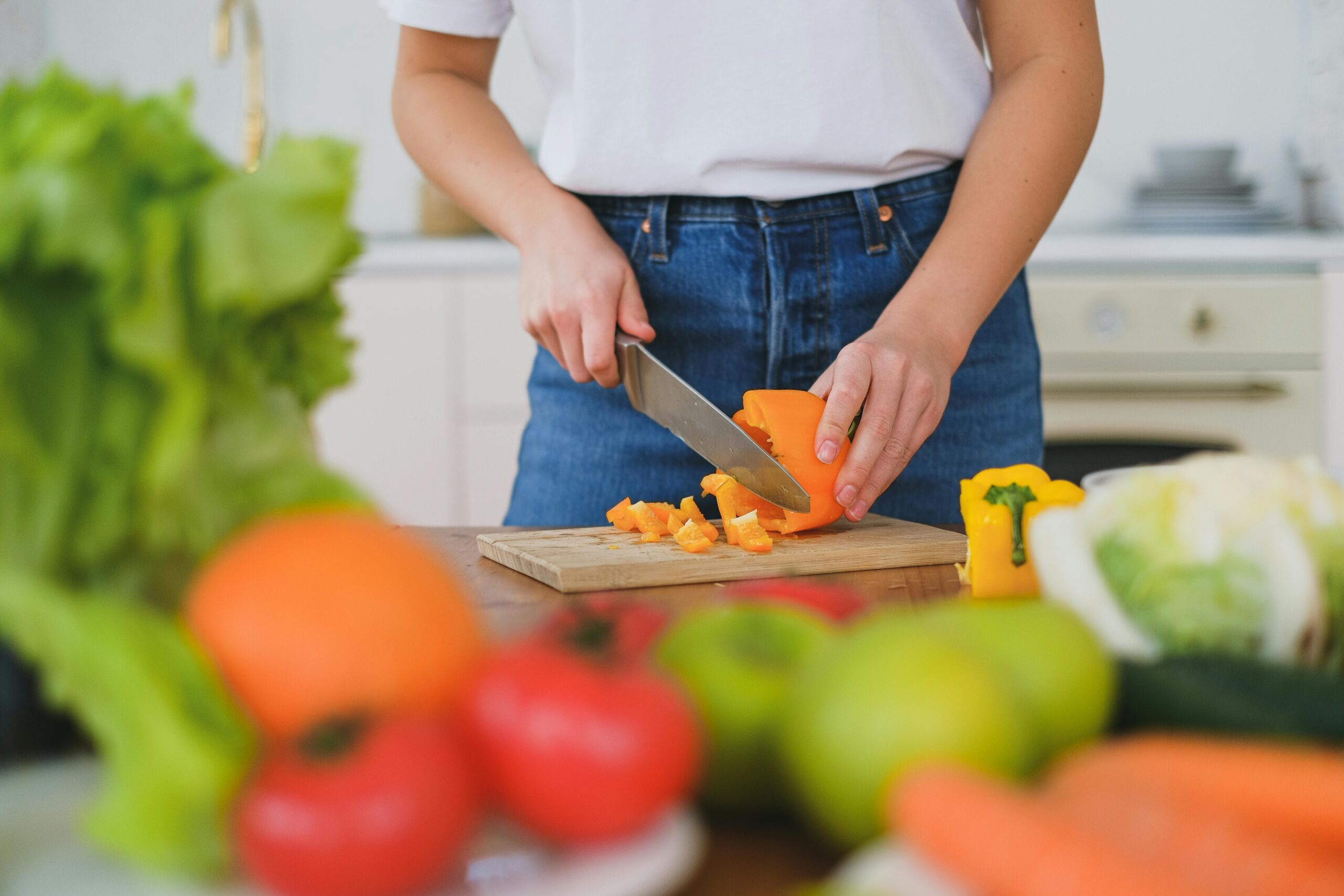 A woman enjoying a colorful salad loaded with organic veggies like spinach, carrots, and bell peppers.