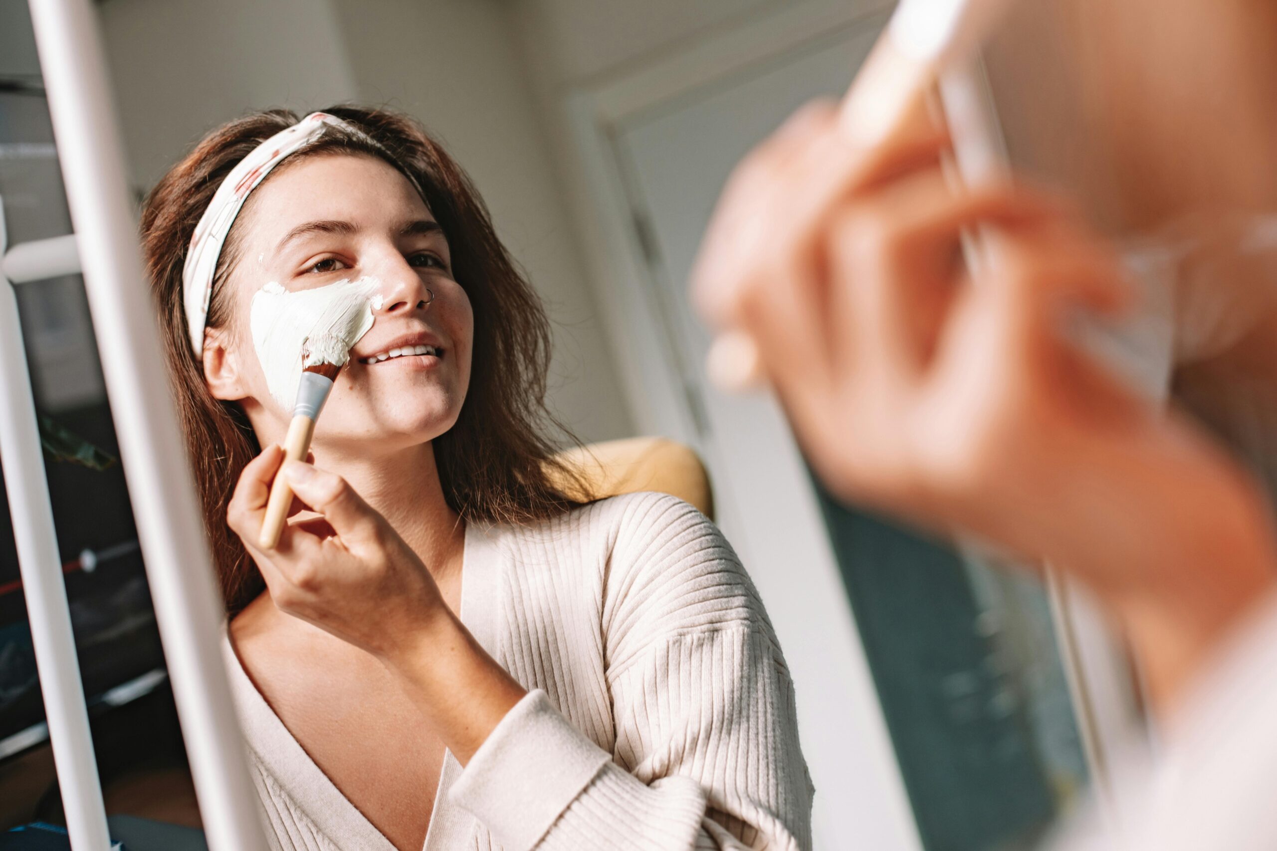 Woman applying homemade avocado and honey face mask