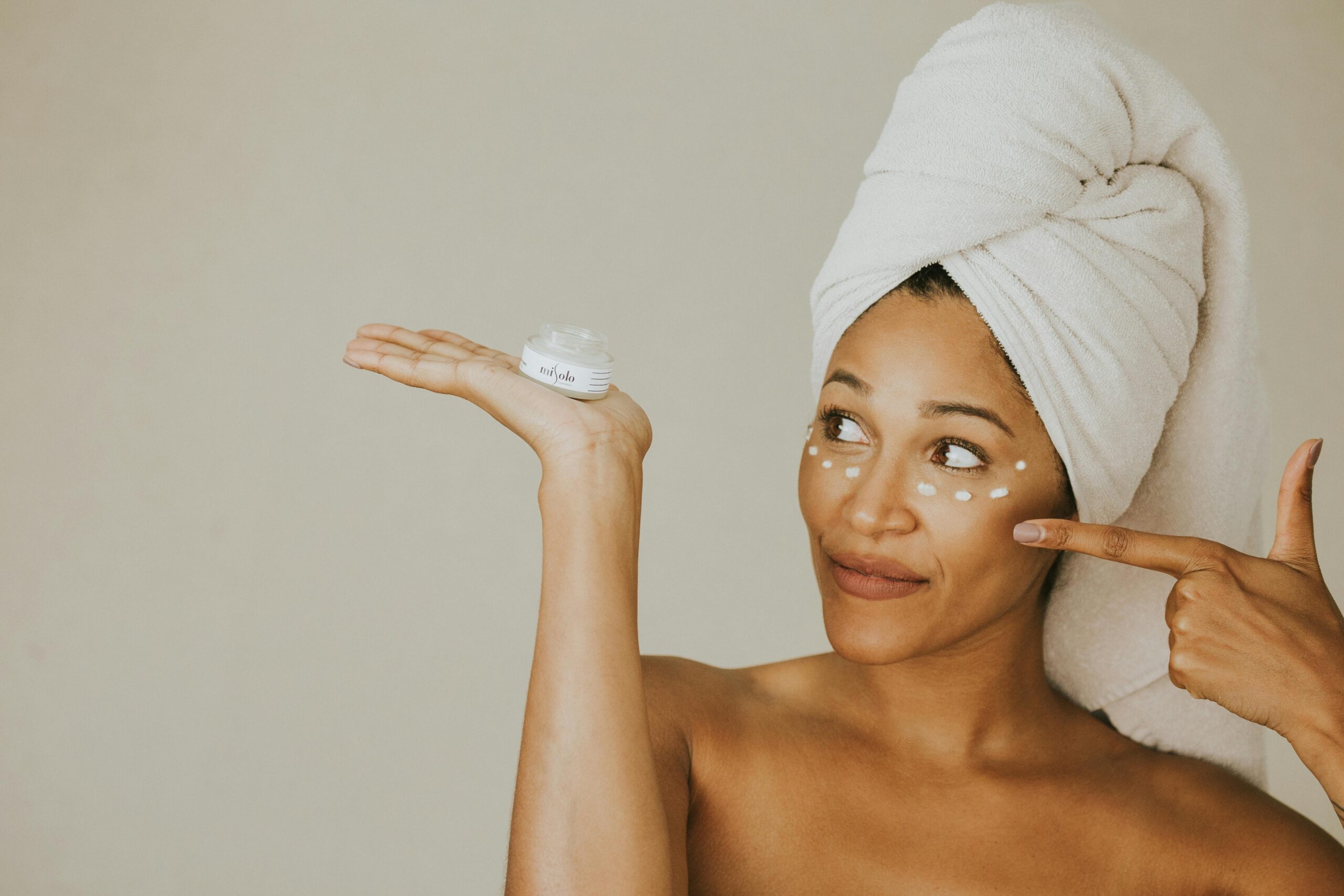 Woman smiling holding a jar of homemade organic skincare mixture