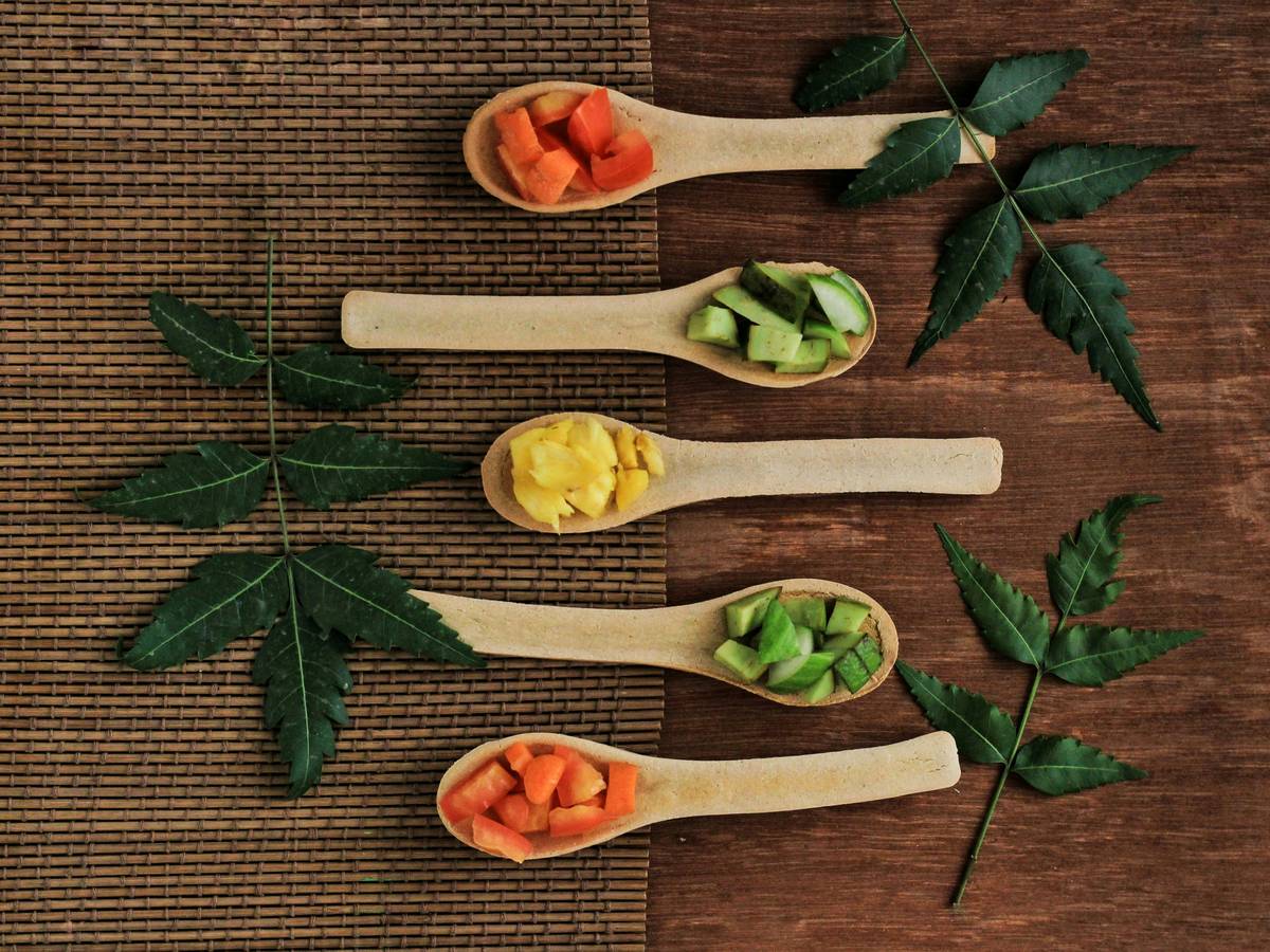 Homemade avocado paste mixed with honey being applied to hands.