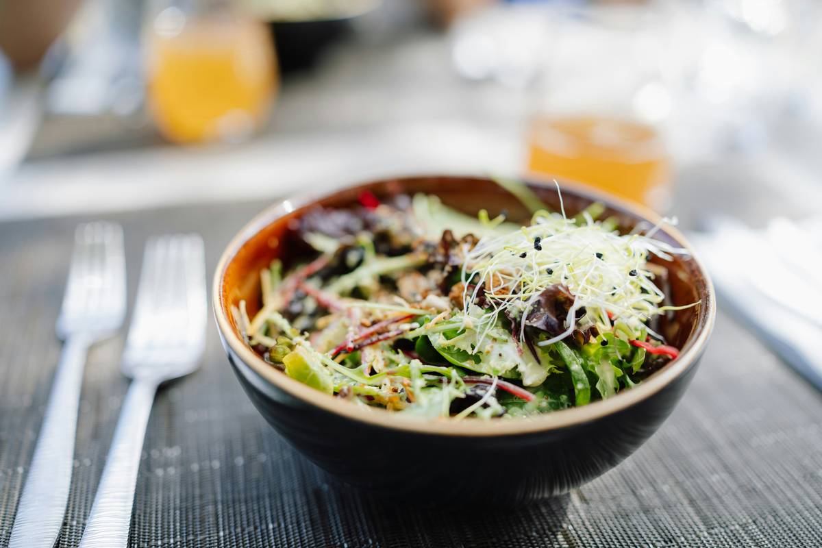 A vibrant bowl of organic vegetables including carrots, spinach, and bell peppers.
