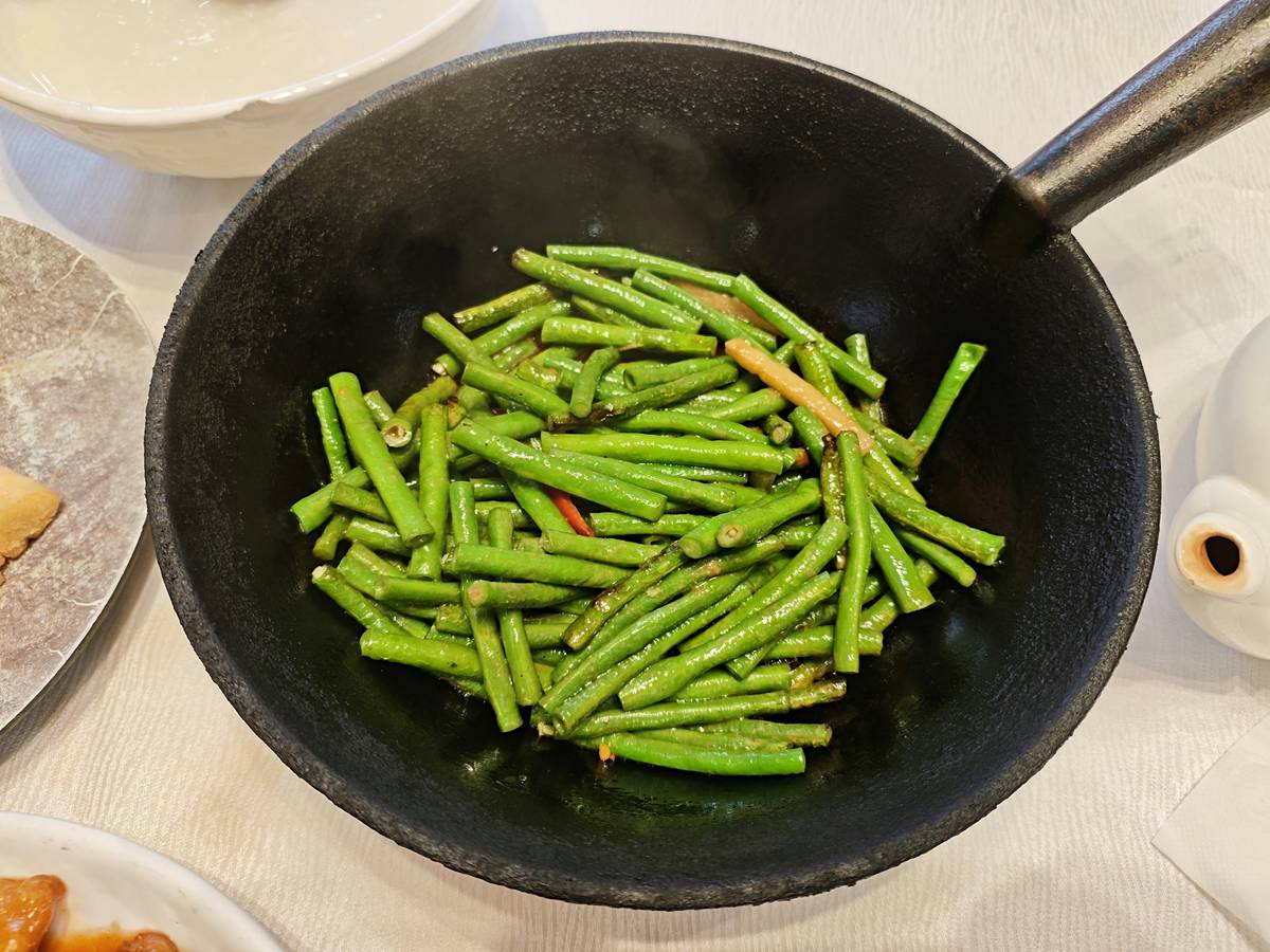 Kitchen counter laid out with cutting boards, knives, and fresh vegetables ready for cooking