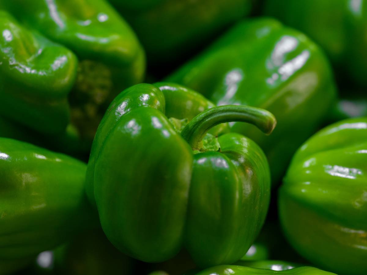 Infographic comparing pesticide residue levels in organic vs conventional bell peppers, with vitamin C content and skin benefits highlighted