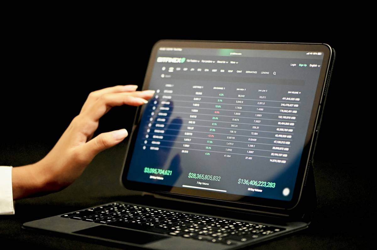 A woman examining market prices on the Bitfinex platform