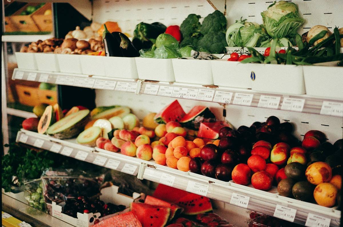 Fresh fruits and vegetables displayed on grocery store shelves.