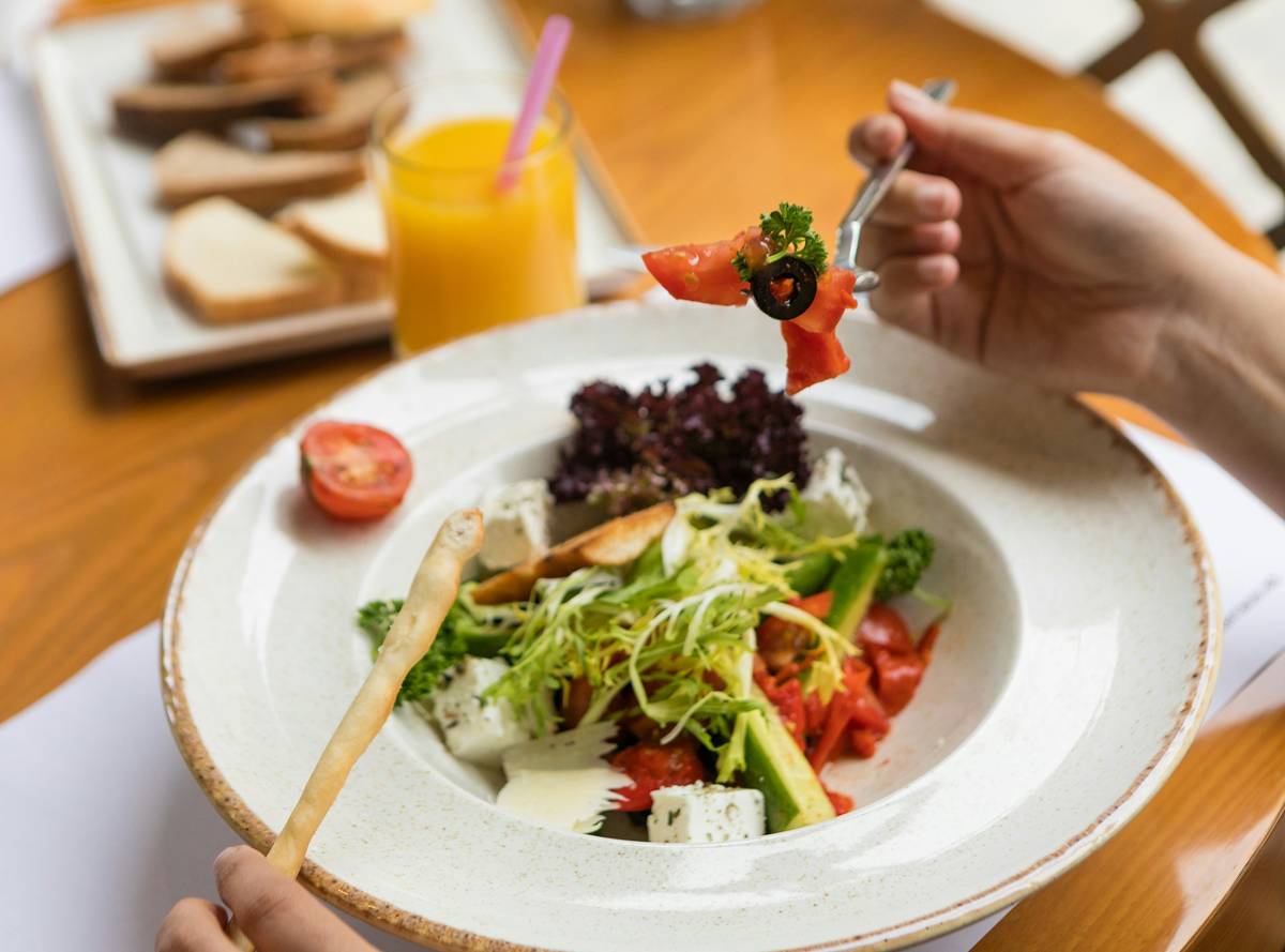 Woman preparing fresh organic vegetable salad for healthy skin and vegetable eating
